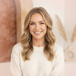 Portrait of influencer Caitlin Covington smiling in a professional, brightly lit setting with a soft-focus background.