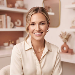 Lauryn Bosstick posing for a professional headshot in a modern, well-lit setting with soft neutral tones.